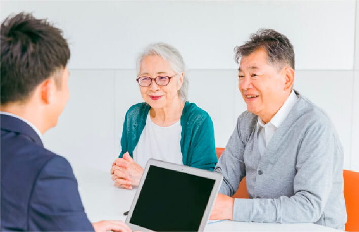 高齢の夫婦が相談員と相談している様子